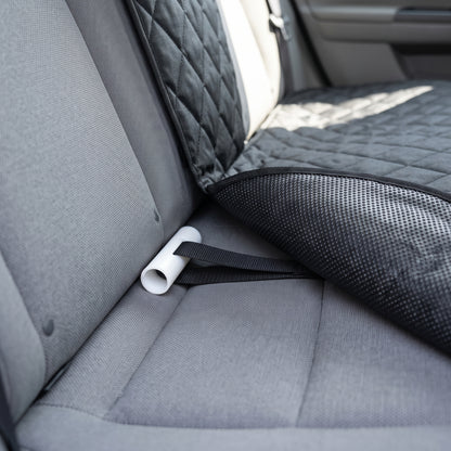 Close-up of the seat anchor tucked into the seat crease, showing the textured non-slip backing