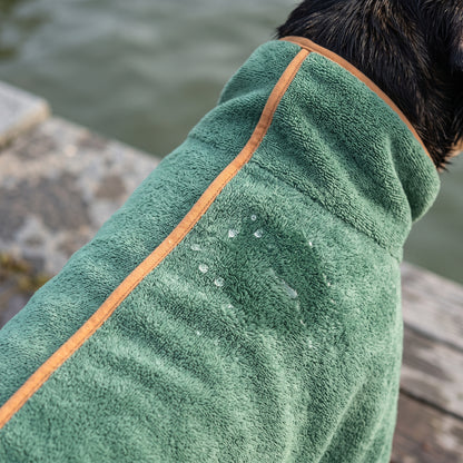 Close-up of the green Dry Dock Robe's microfiber pile with water beaded on the surface and orange trim along the seam.
