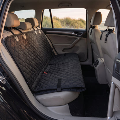 The same seat cover with the front panel folded back and strapped flat, leaving the footwell clear